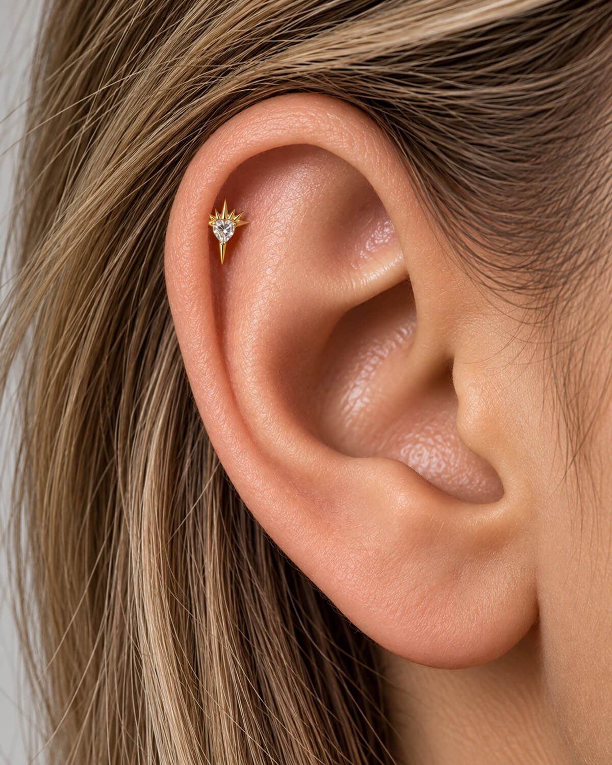 woman woman with helix piercing wearing sacred earring by auricle.