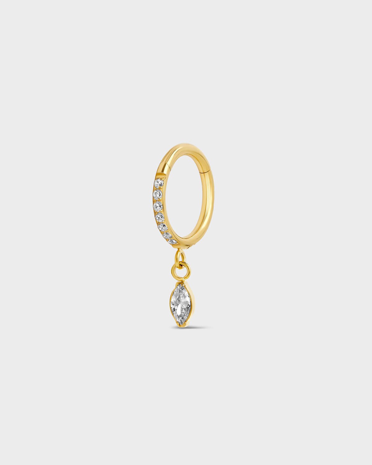 Gold titanium hinged ring with clear pave gemstones around the outer edge and a single dangle marquise charm sat on a light gray background.