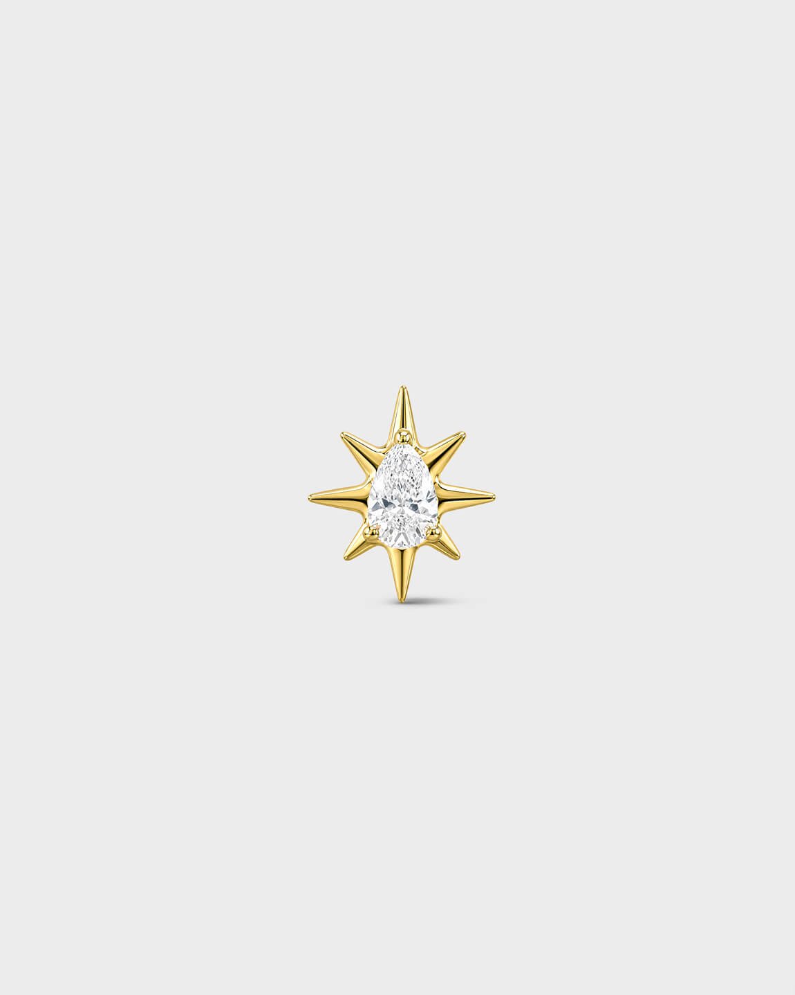 Gold titanium threadless end with a marquise-cut clear stone set within a sculpted starburst design. On a light grey background.