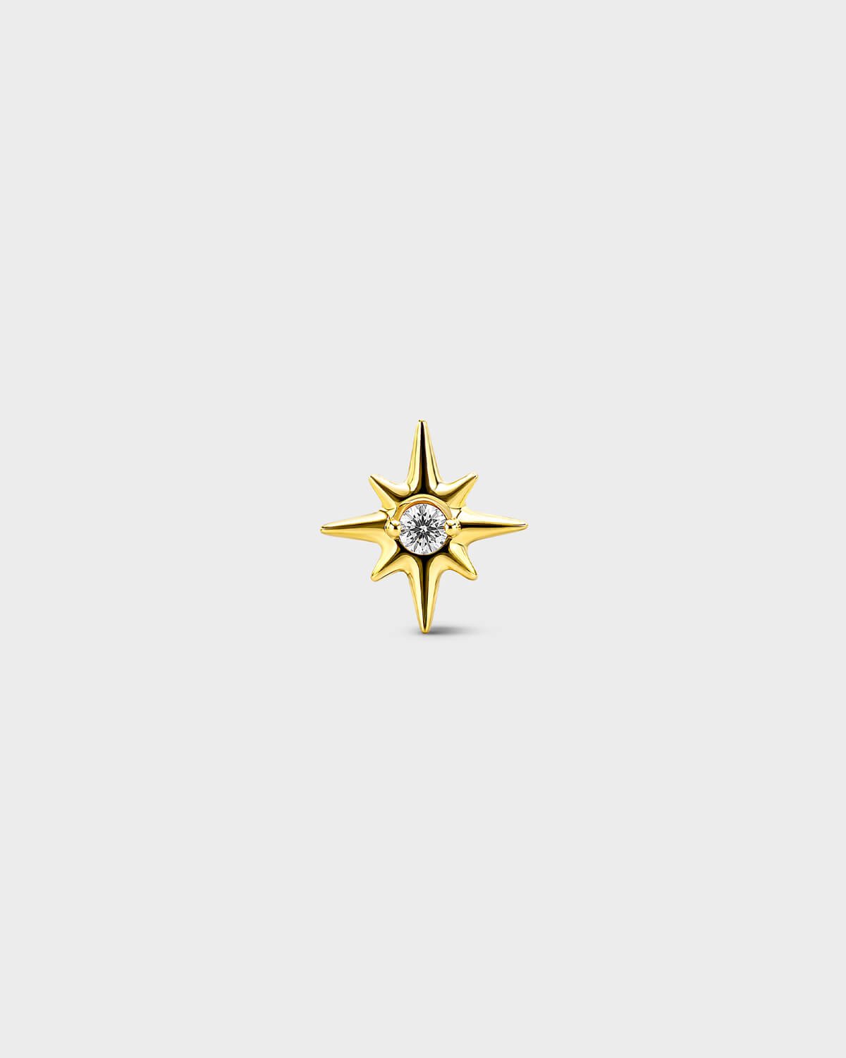 Gold titanium threadless end earring with a round-cut clear stone set within a sculpted star design. On a light grey background.