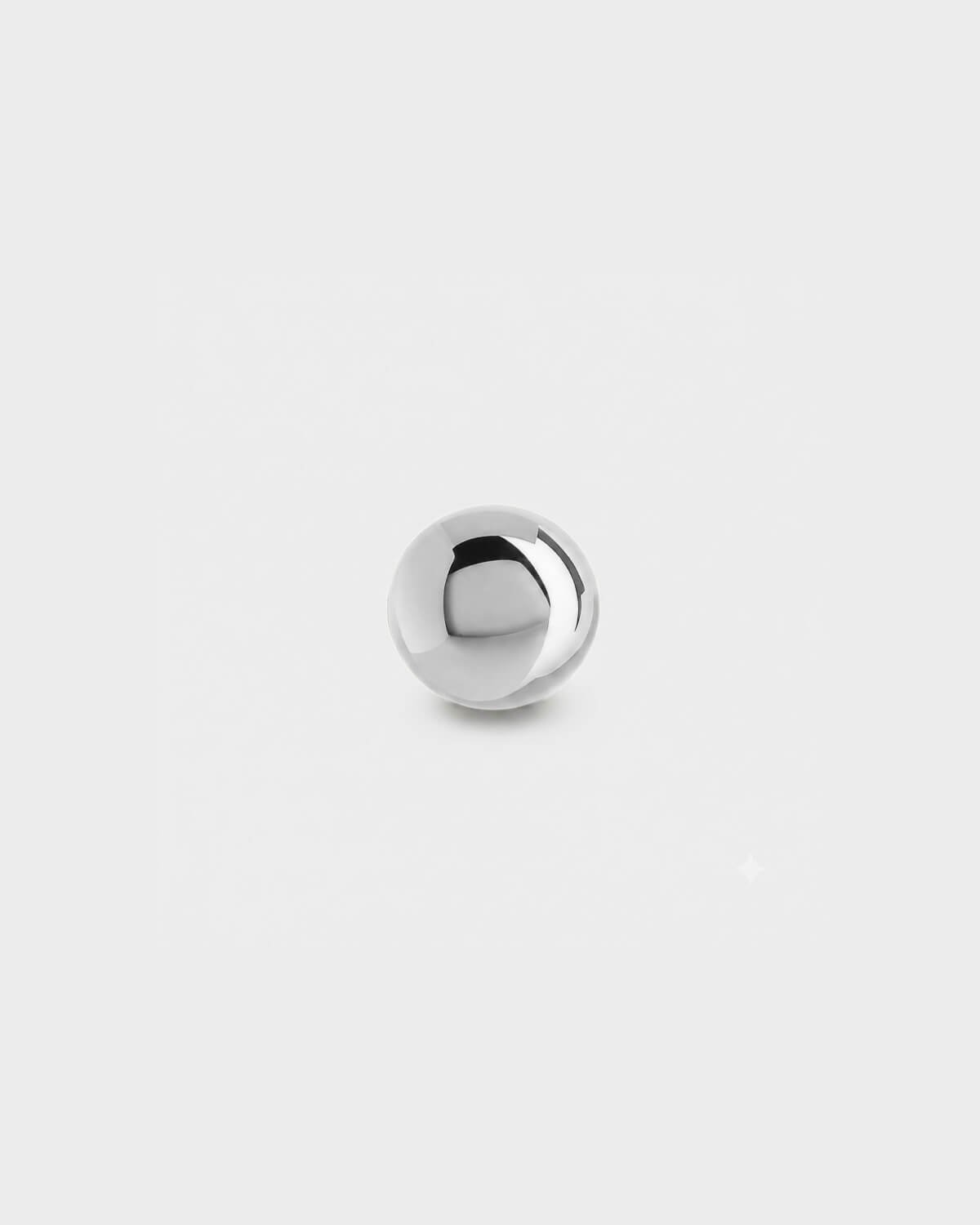 Plain polished silver titanium ball for piercing jewellery on a light grey background