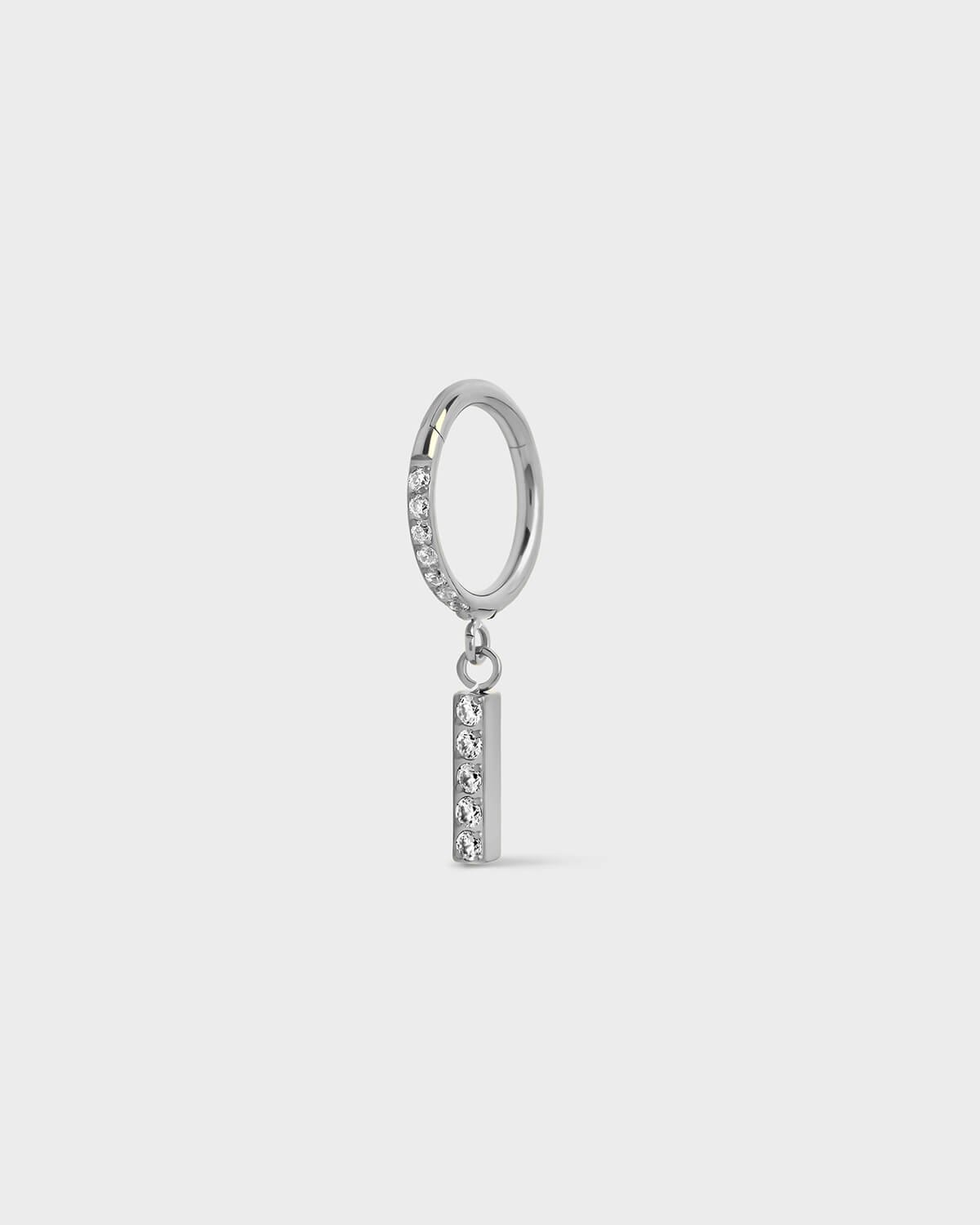 Polished silver titanium ring with pavé set gems along the front edge, finished with a vertical bar drop accented by a row of matching pavé stones. On a light gray background.