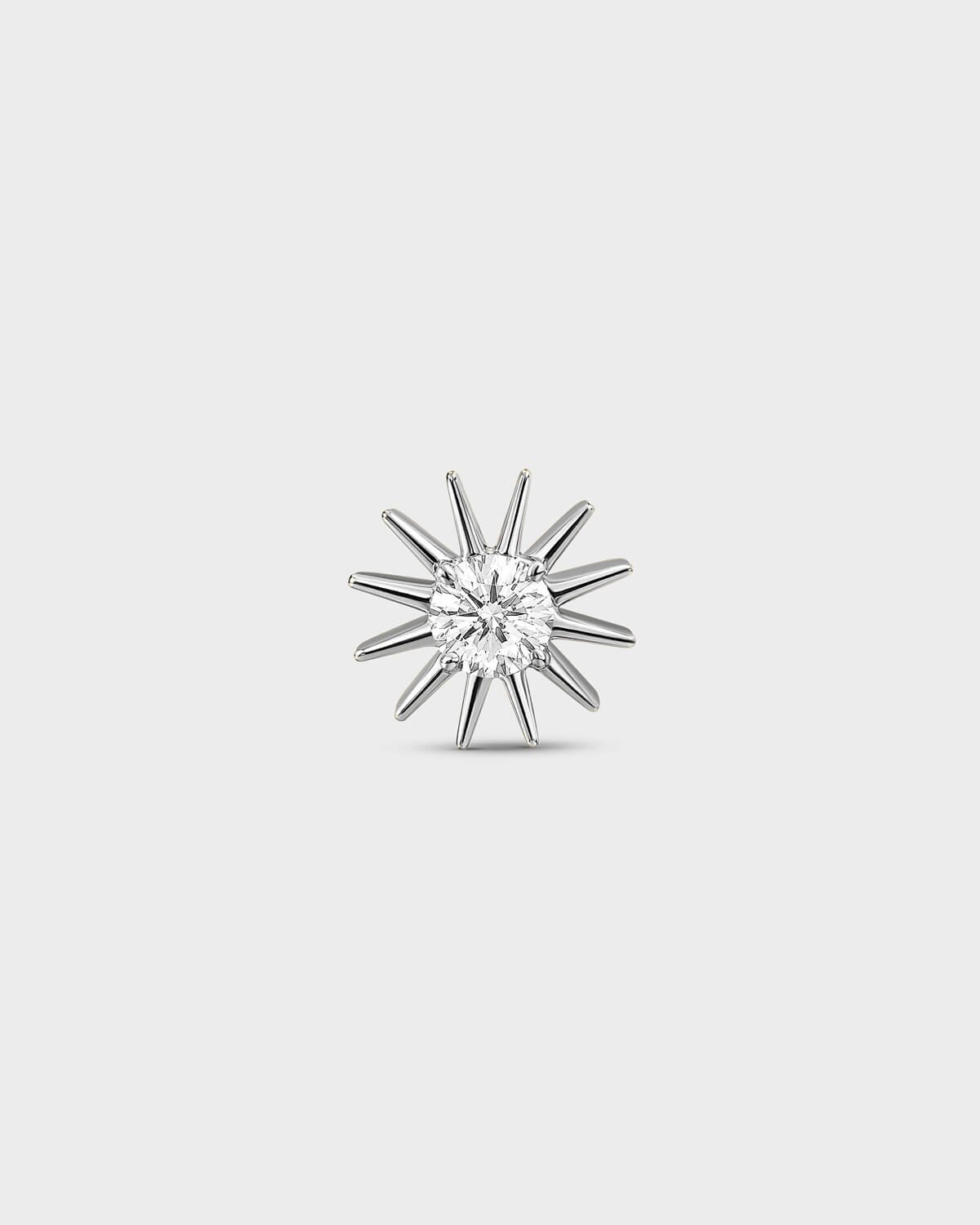 Polished silver Titanium threadless end earring with a round-cut clear stone set within a sculpted starburst design. On a light grey background.